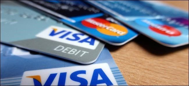 Four credit cards placed on a table over each other.