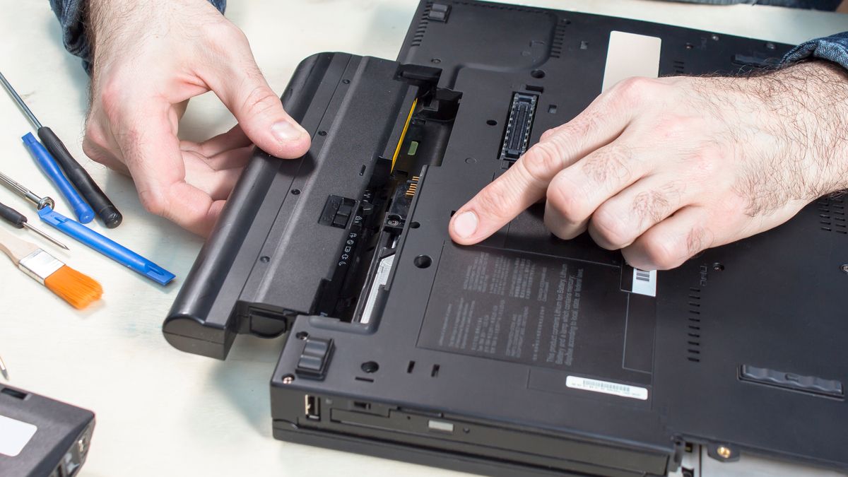 Person checking and removing the battery from a laptop