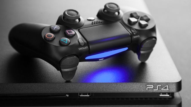 Dualshock 4 controller on top of a PlayStation 4
