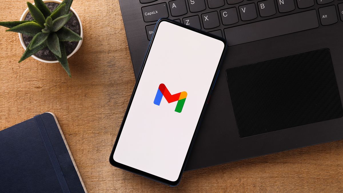 Gmail logo on a smartphone next to a computer