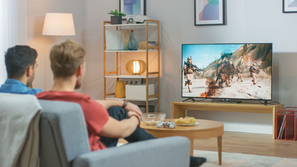 Two people watching an action movie on a TV