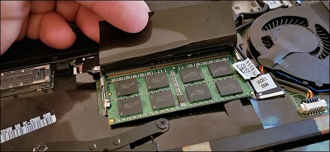 A laptop's RAM, visible under a black flap. 