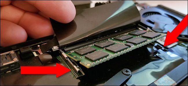 Pull the tabs on either side of the laptop RAM module to release it, then gently pull on the stick to remove it. 