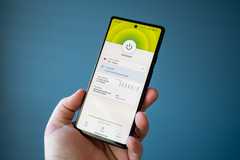 Man holding a phone with a VPN app showing 'Connected' status.