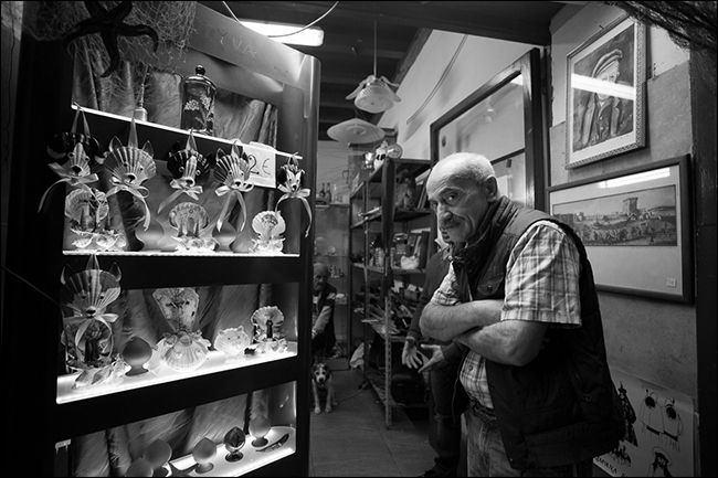 Older man with folded arms in curio shop