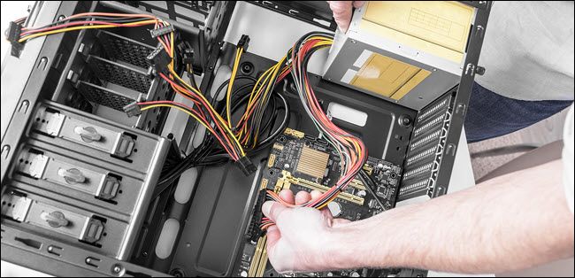 technician installing power supply in a PC