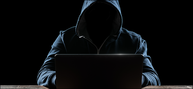 A hooded hacker in front of his computer