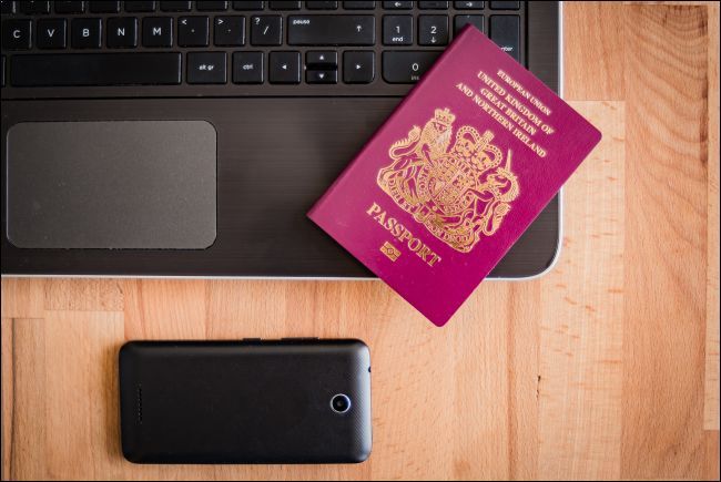 UK passport with laptop and smartphone