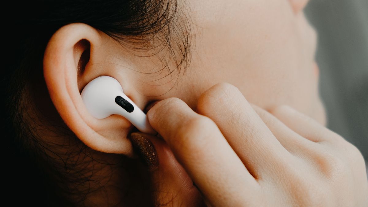 Person using the touch controls on Apple AirPods