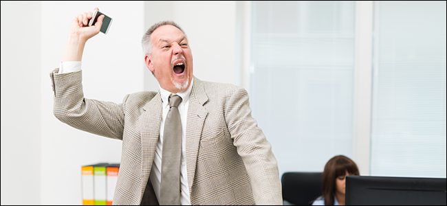 An angry businessman throwing away his phone.