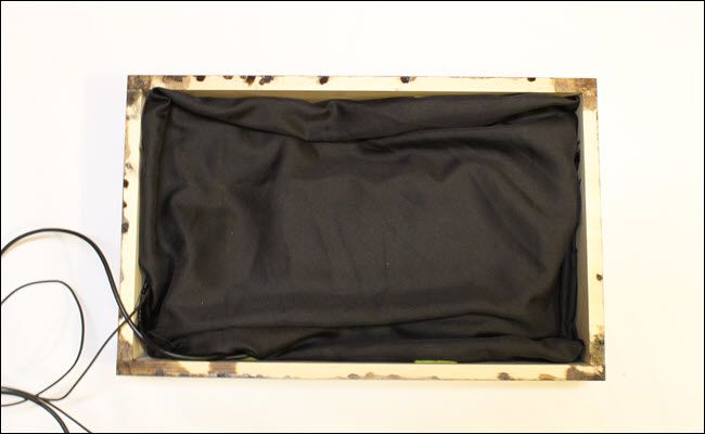Frame box with draped black cloth.