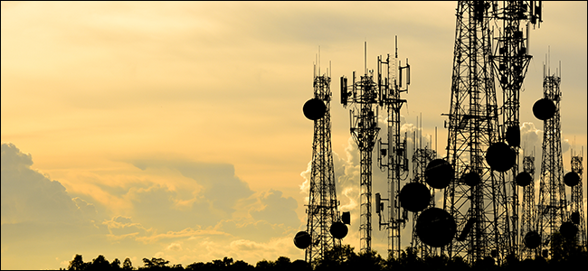 A bunch of broadcasting towers flanked by a beautiful sunset.