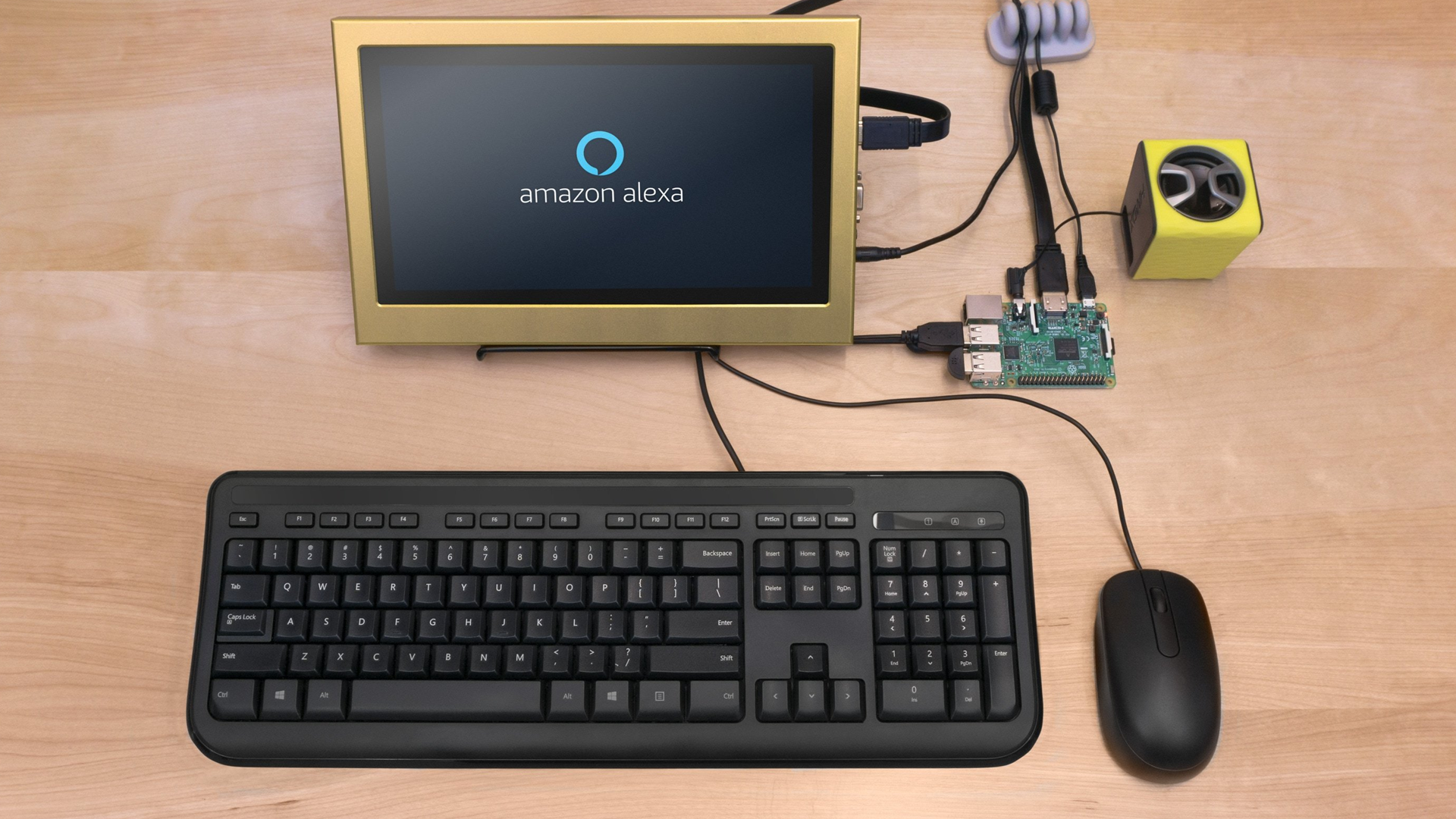 A keyboard, mouse, and monitor with Amazon Alexa on the screen connected to a Raspberry Pi.