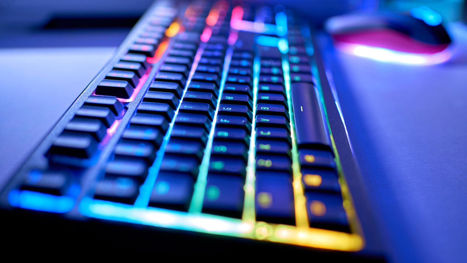 Gaming keyboard with RGB LED light, blurred background, selective focus, bokeh