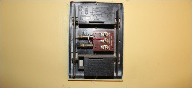 A chime box with wiring exposed, a red wire on the trans terminal and white on the front terminal.