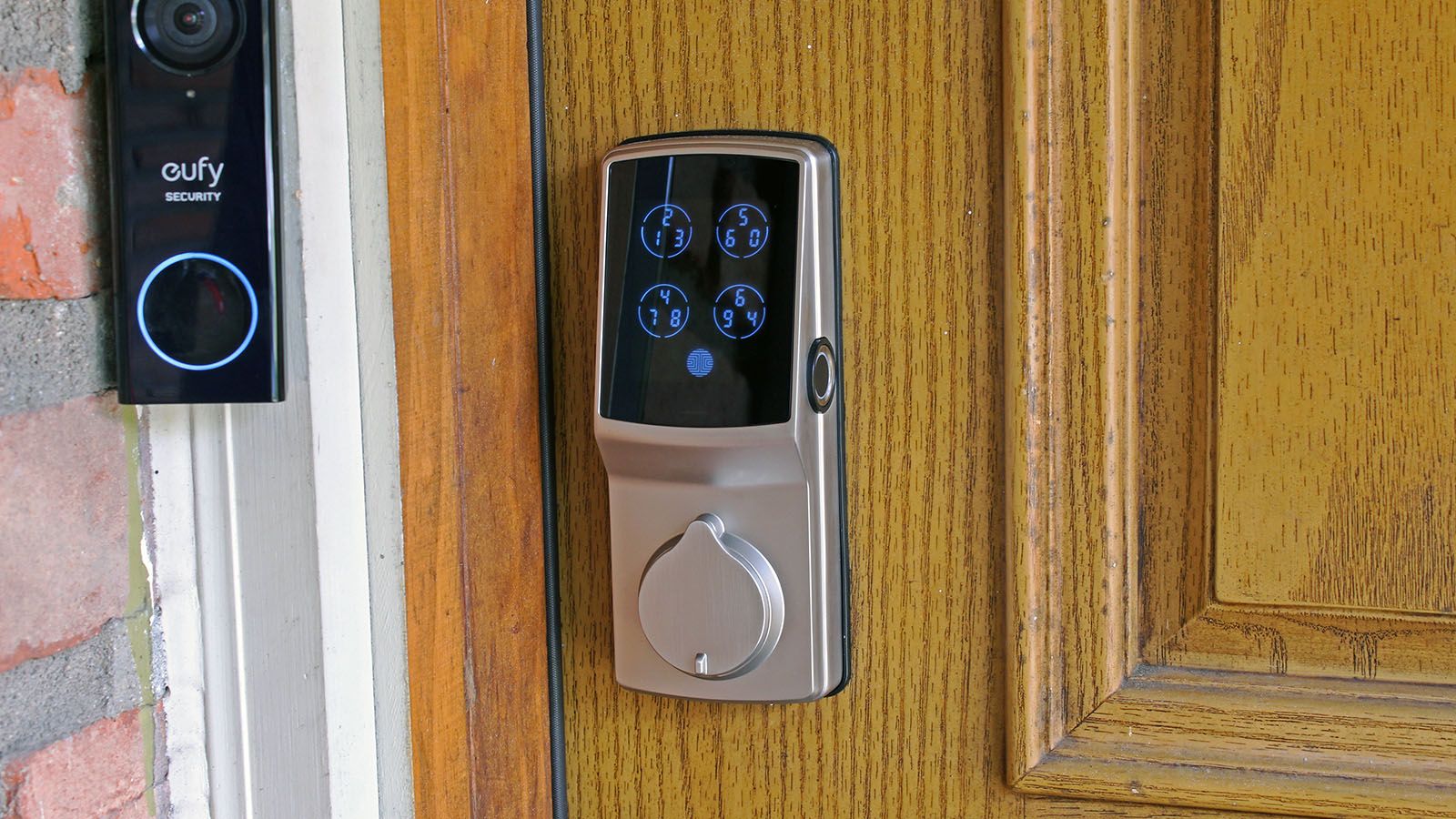A large ugly smart lock on a brown door