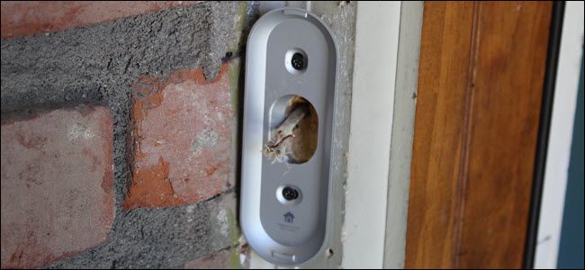 A Nest Hello mounting bracket attached to a door frame with wires poking through.