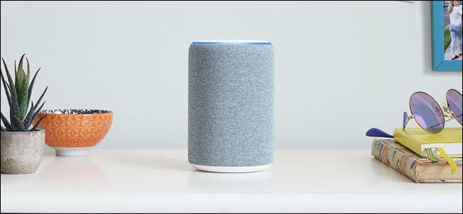 A gray Amazon Echo roughly in the center of a room.