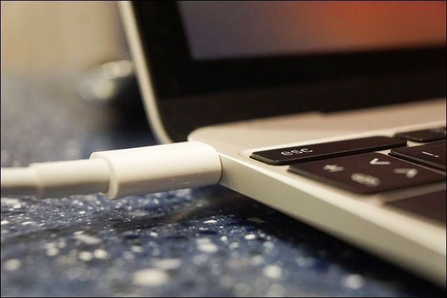 A power cable connected to a MacBook.