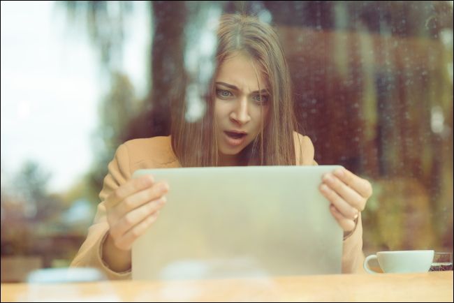 Woman with a shocked expression looking at laptop screen