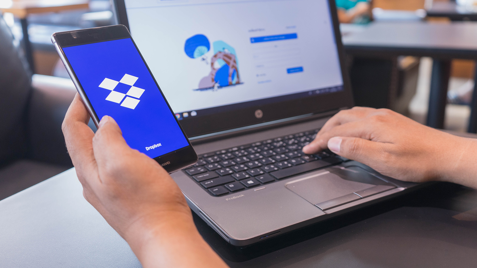 A person using Dropbox on their phone and computer.