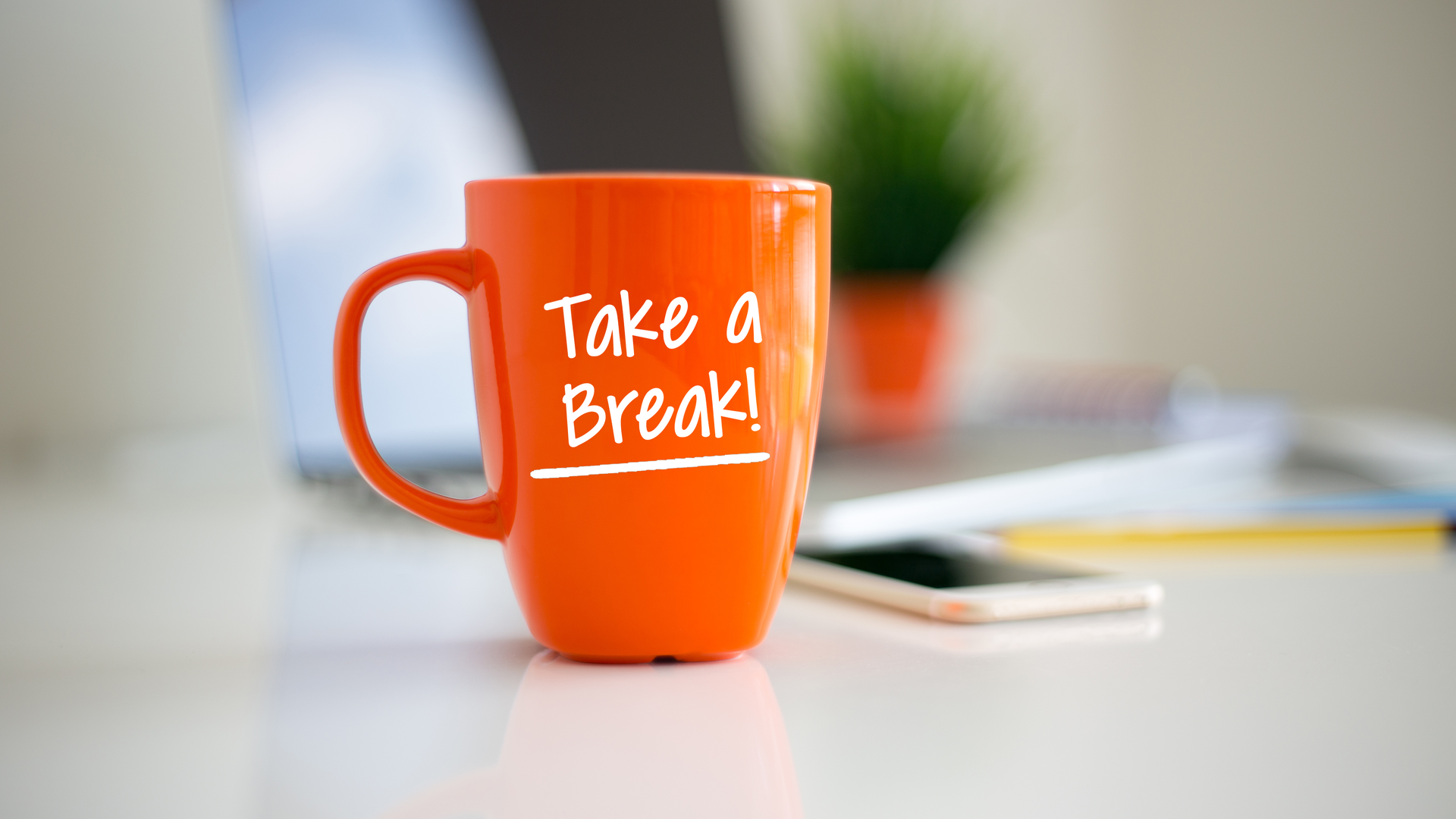 A bright orange coffee cup with the words &quot;Take a Break!&quot; in white letters