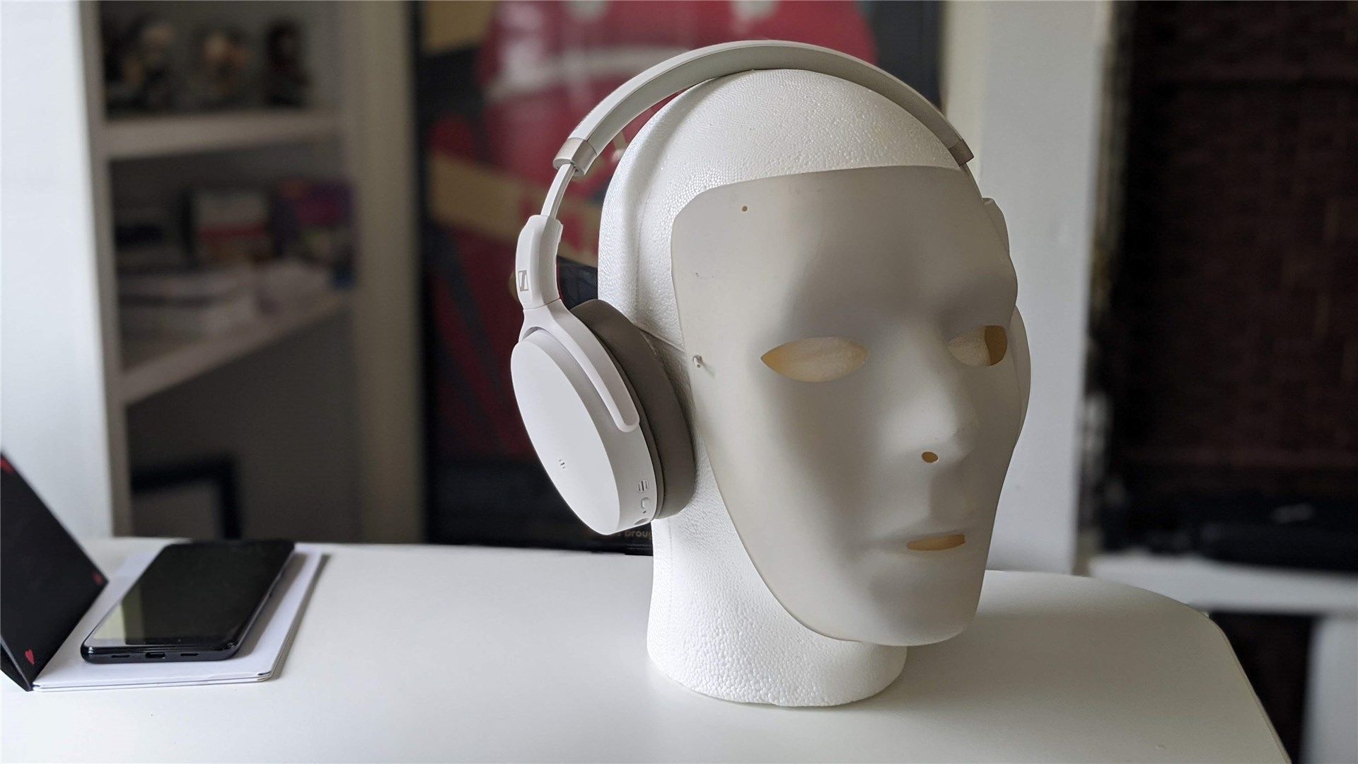 A Styrofoam mannequin head and white mask wearing the Sennheiser HD 450BT headphones
