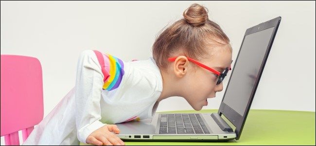 Kid in Glasses Leaning Into Laptop