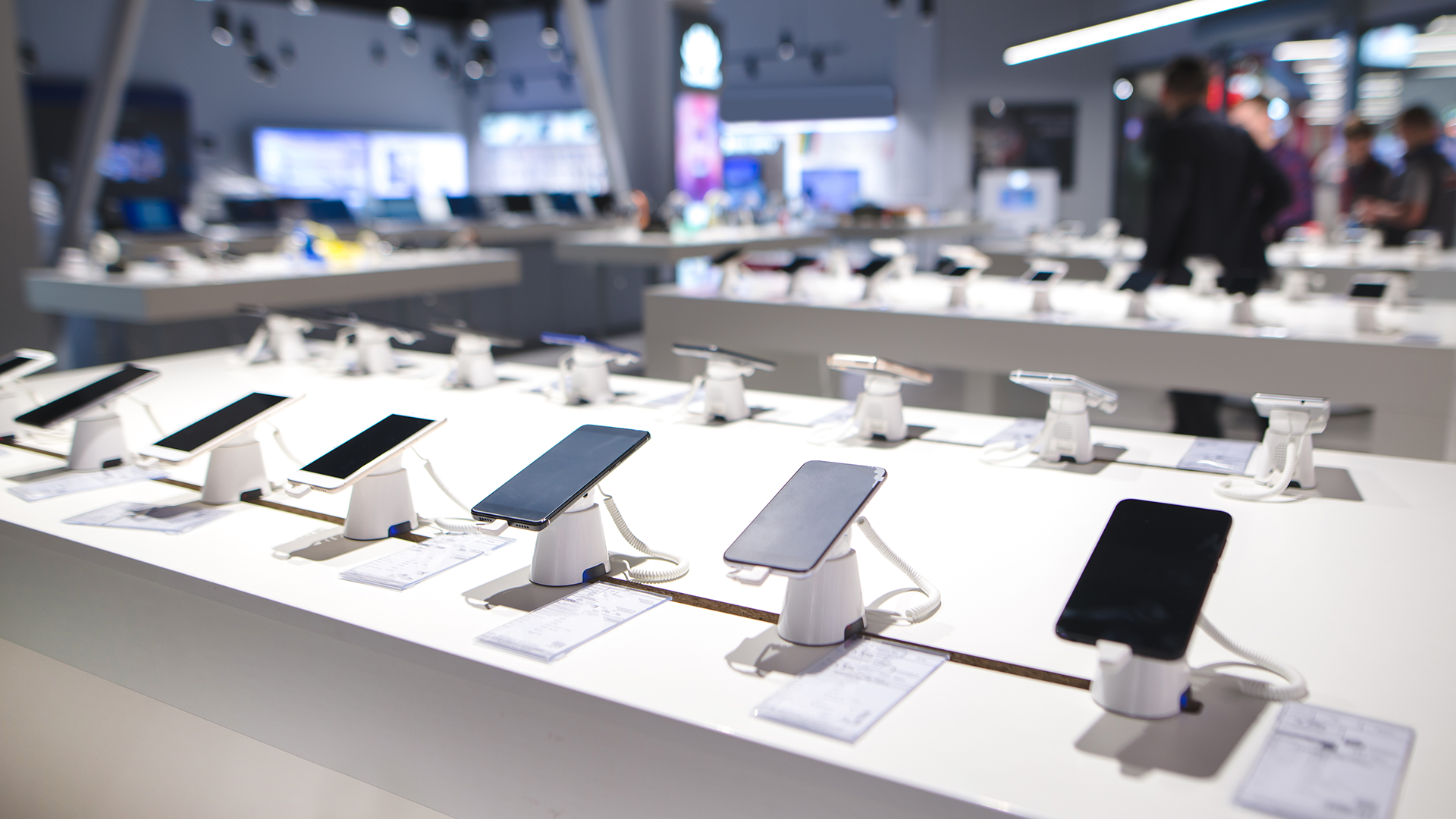 A lineup of new phones at an electronics store.