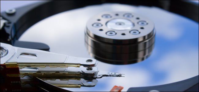 An exposed hard drive platter with the read/write head over top it.