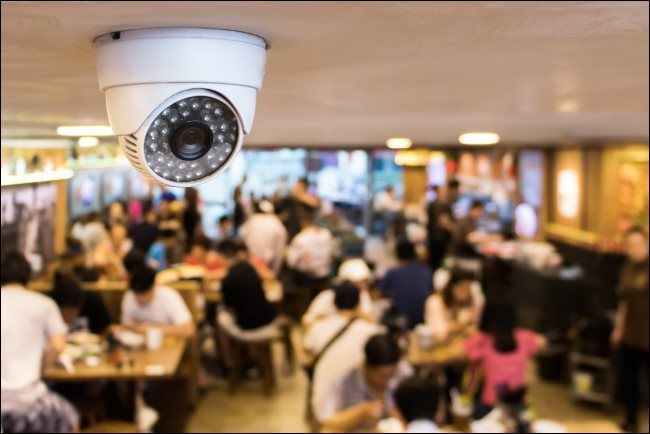 A CCTV security surveillance camera on the ceiling of a restaurant.