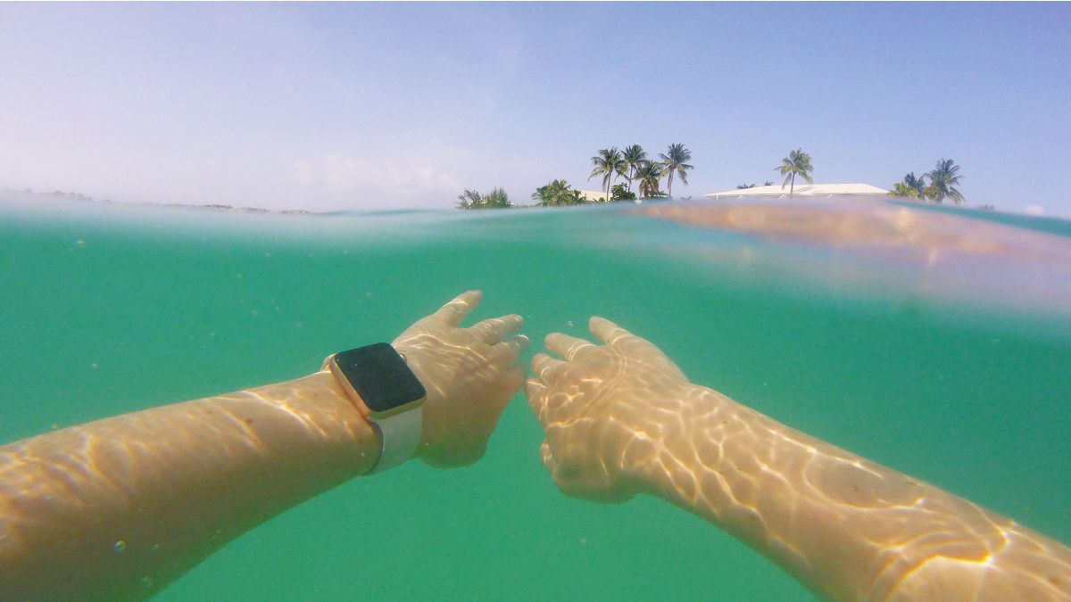 Person swimming in the ocean while wearing an Apple Watch