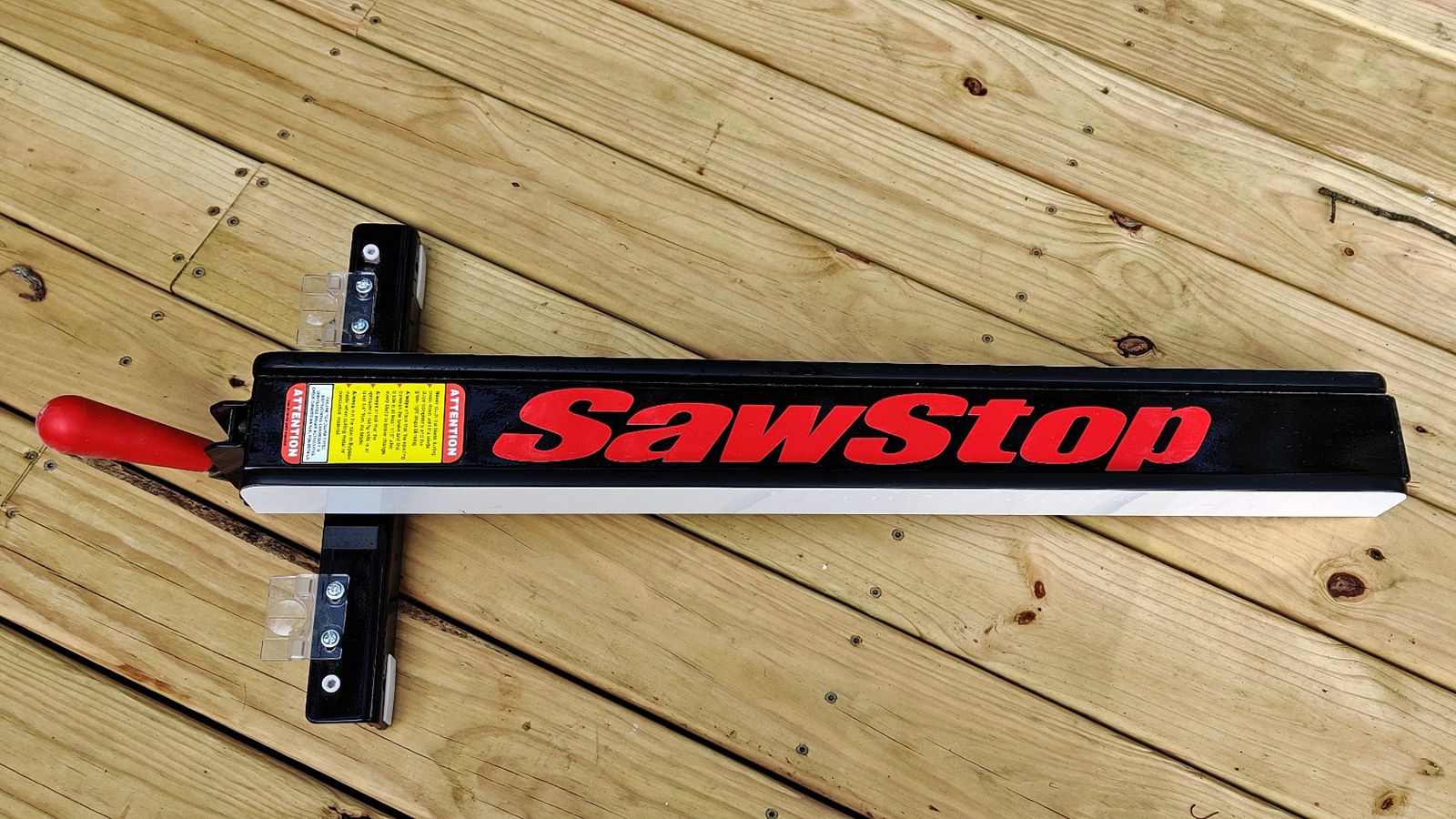A closeup of a Sawstop T-Glide fence on a wood deck.
