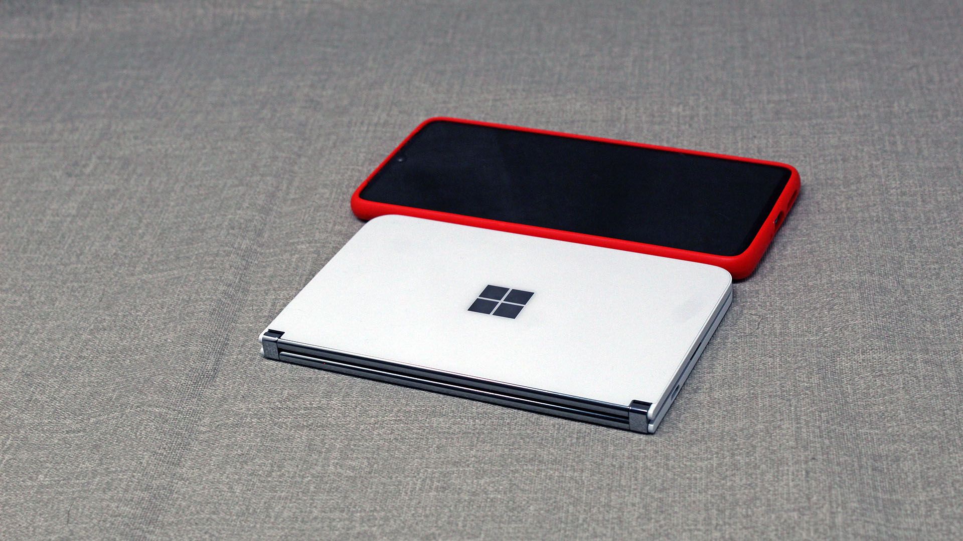 A Surface Duo next to a phone in a case, each about the same width.