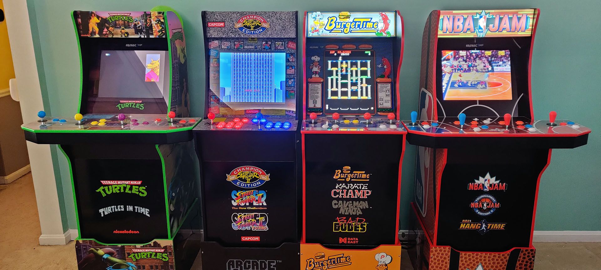 Four Arcade1Up machines standing in a row, all with nearly identical profiles.