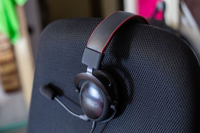 A gaming headset sitting on an empty computer chair