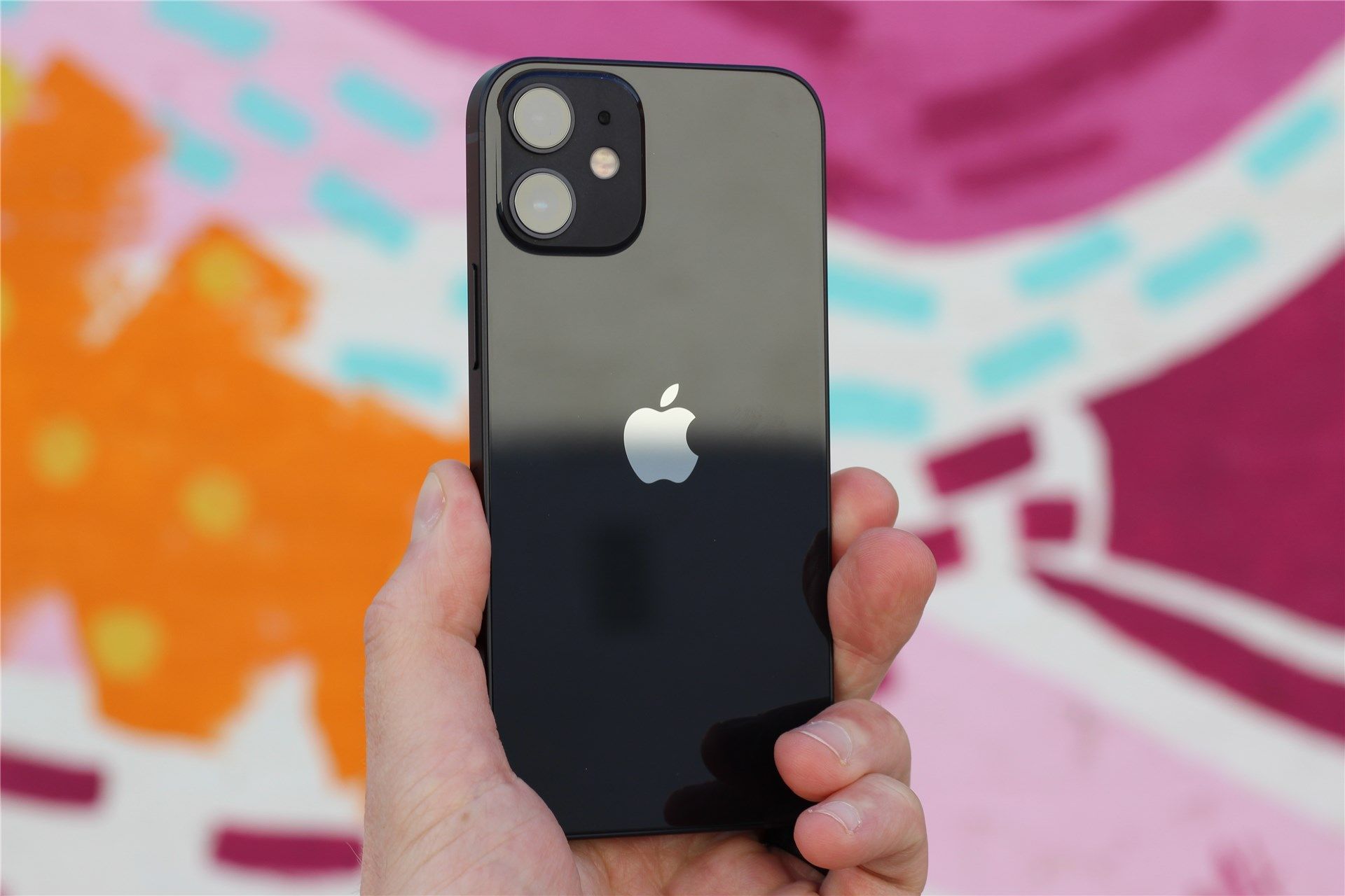 The back of the black iPhone 12 Mini with a colorful background