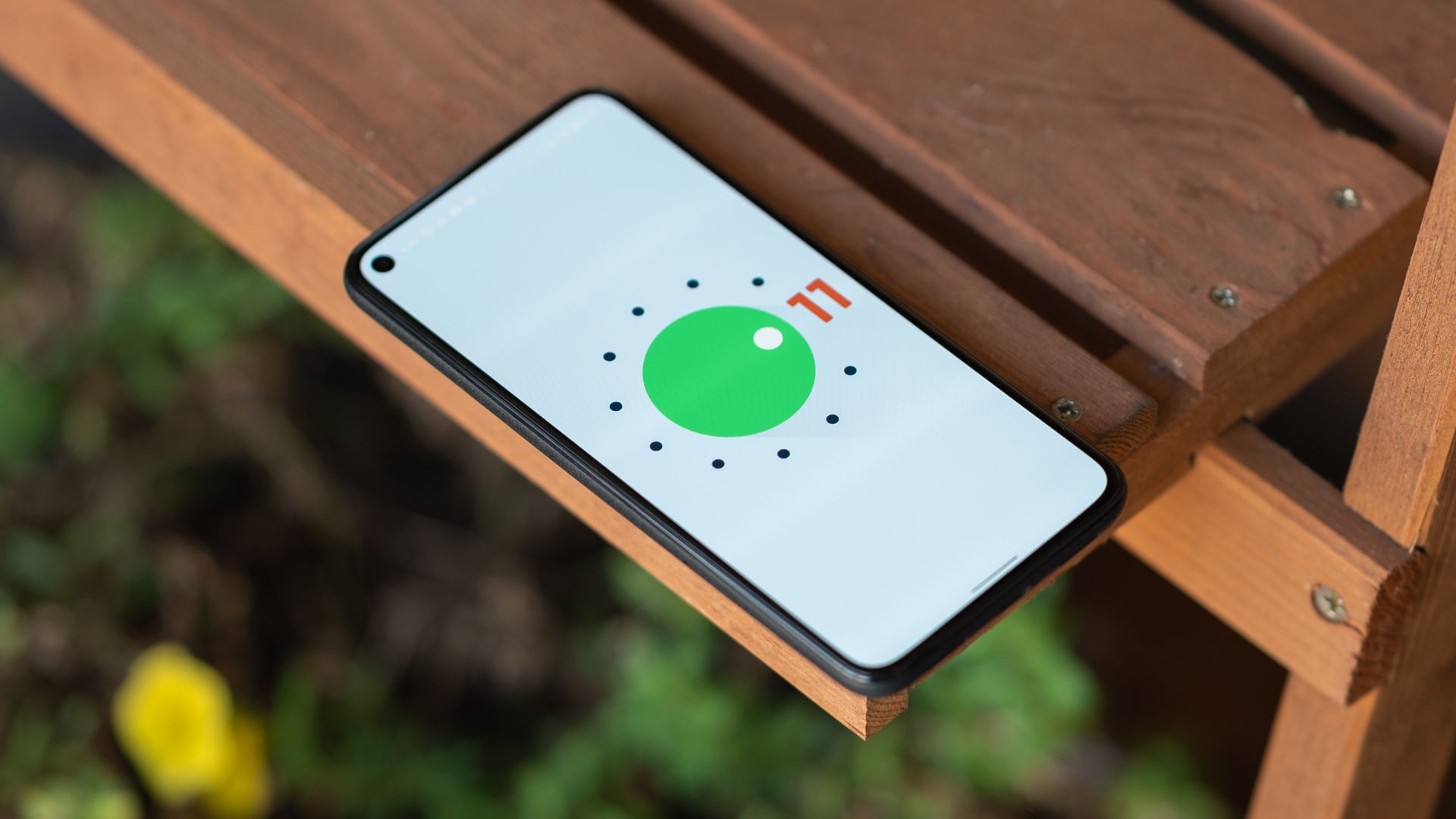 The Pixel 5 on a wooden table with the Android 11 easter egg screen. 