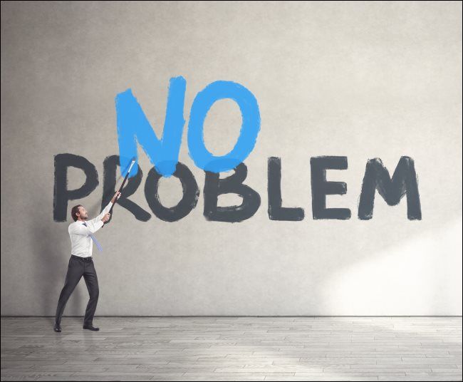 A man painting &quot;No Problem&quot; on a wall.