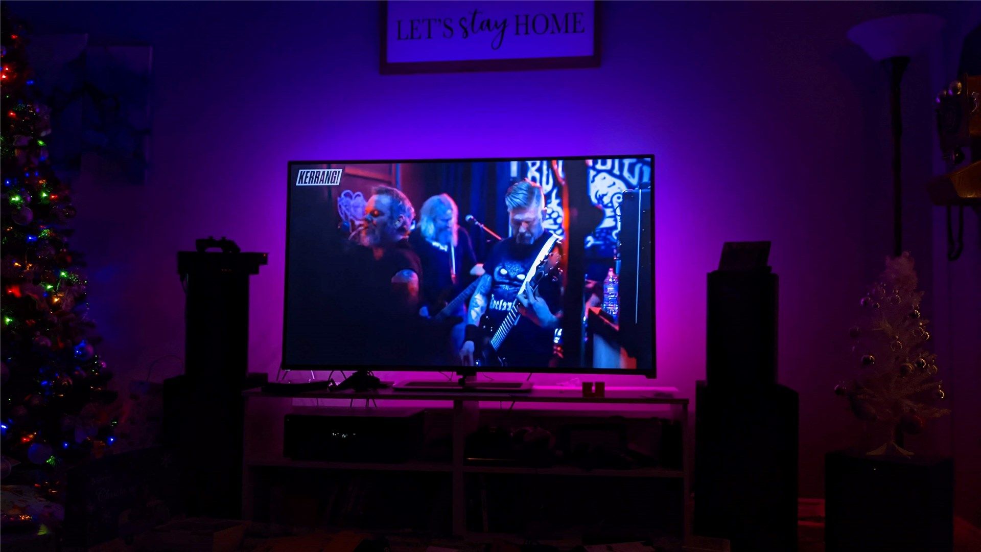 The Immersion glowing blue, purple, and pink behind a TV showing a live concert