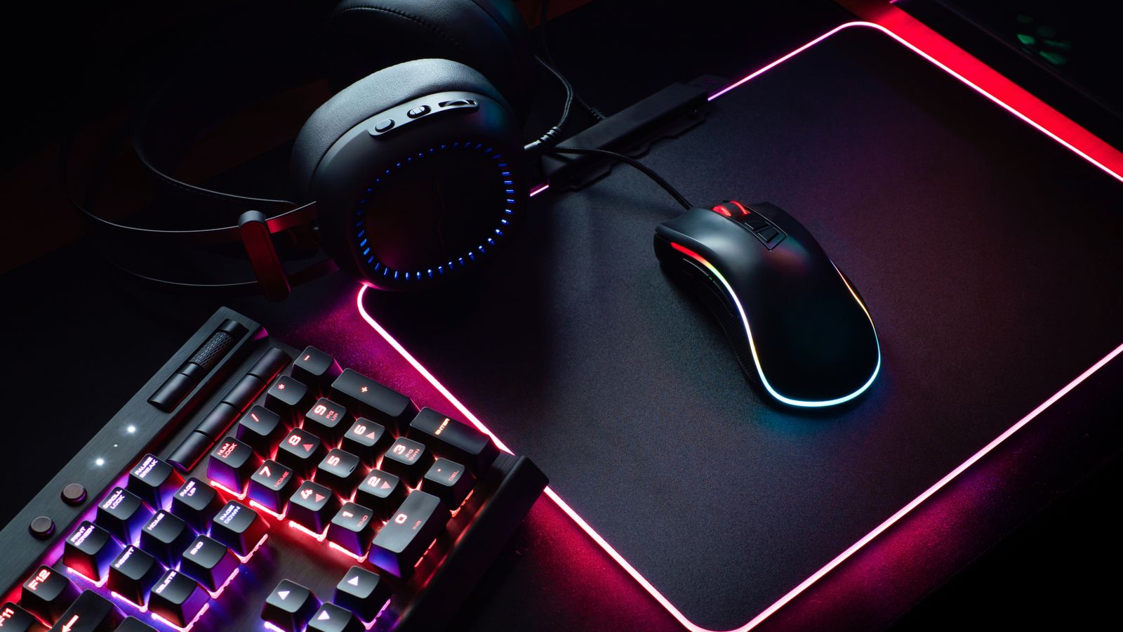 Gaming keyboard, headset, and mouse arranged on a desk