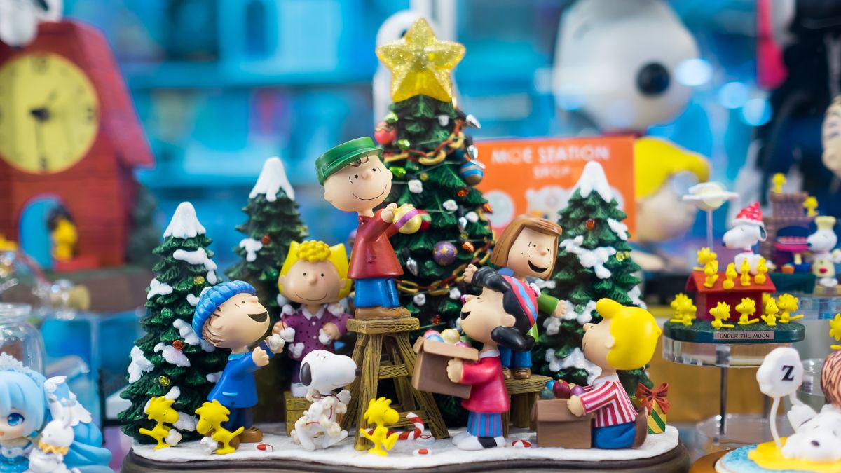 Decorative display of Peanuts characters decorating a Christmas tree.