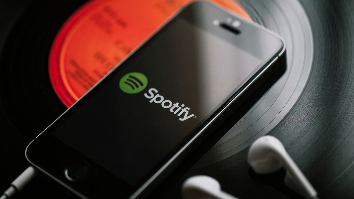Spotify logo on a smartphone sitting on a record