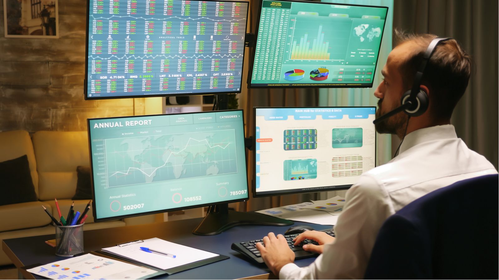 Stock trader operating multiple monitors stacked on top of each other