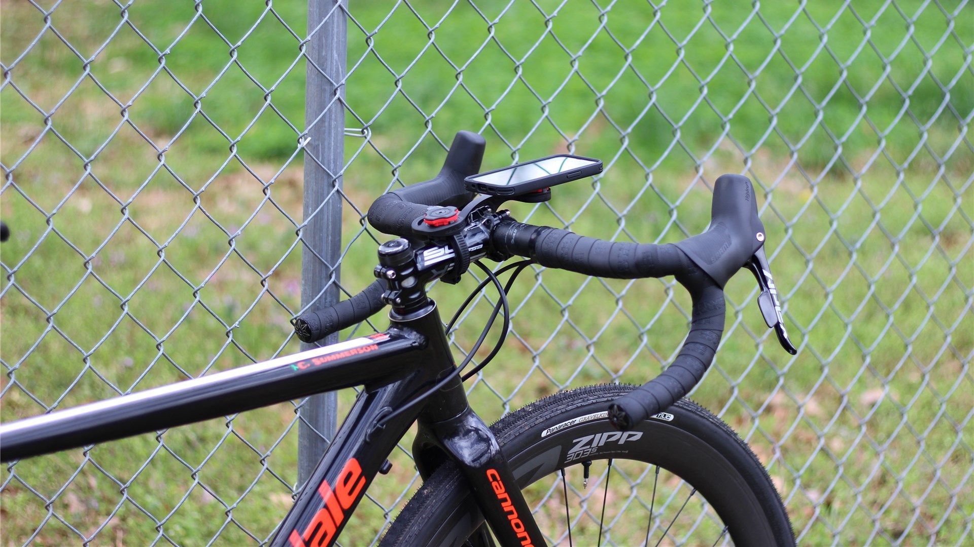 A Cannondale CAADX gravel bike with Spigen's Gearlock stem and out-front mounts installed. An iPhone 12 Mini is on the out-front mount.
