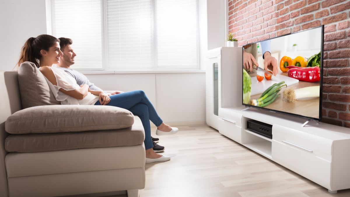A couple watching a food TV show on television
