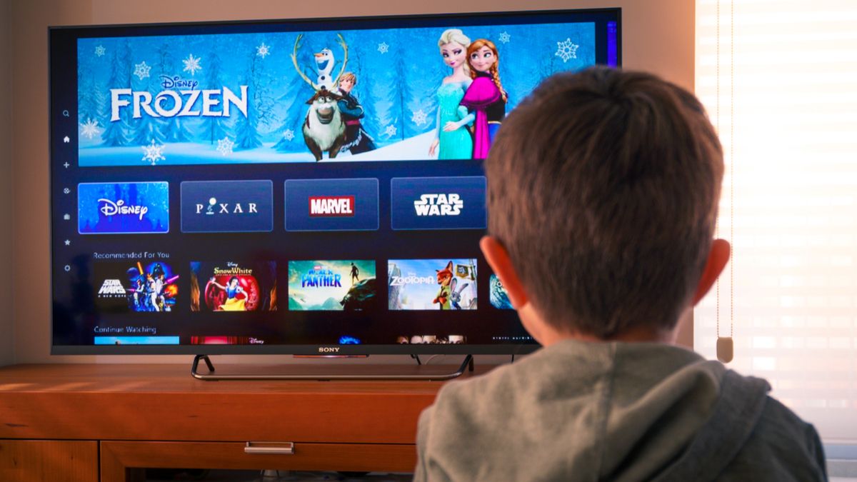 A kid watching Disney+ on a TV
