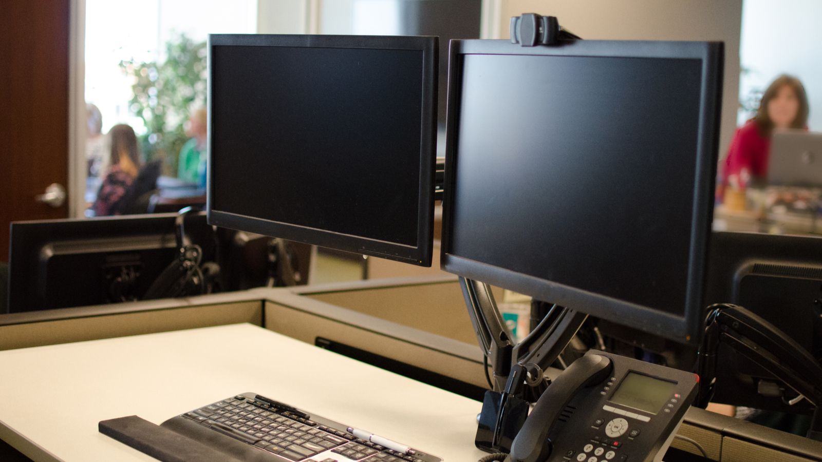 Two monitors on a stand in an office