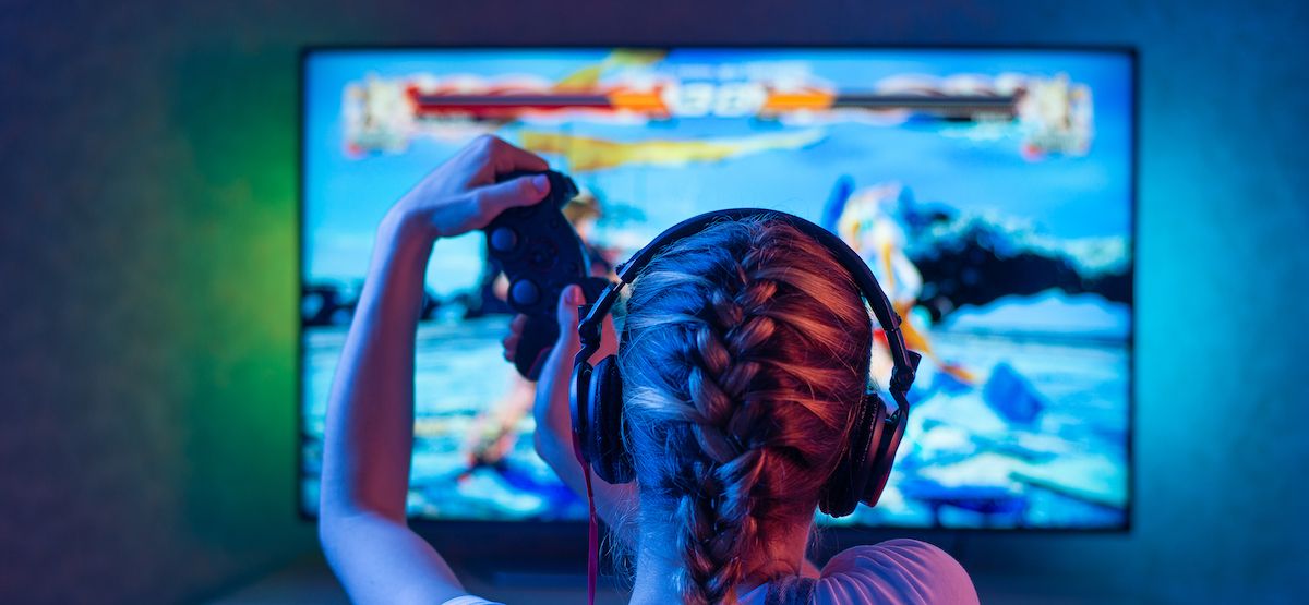Person playing video games on a TV with back lighting