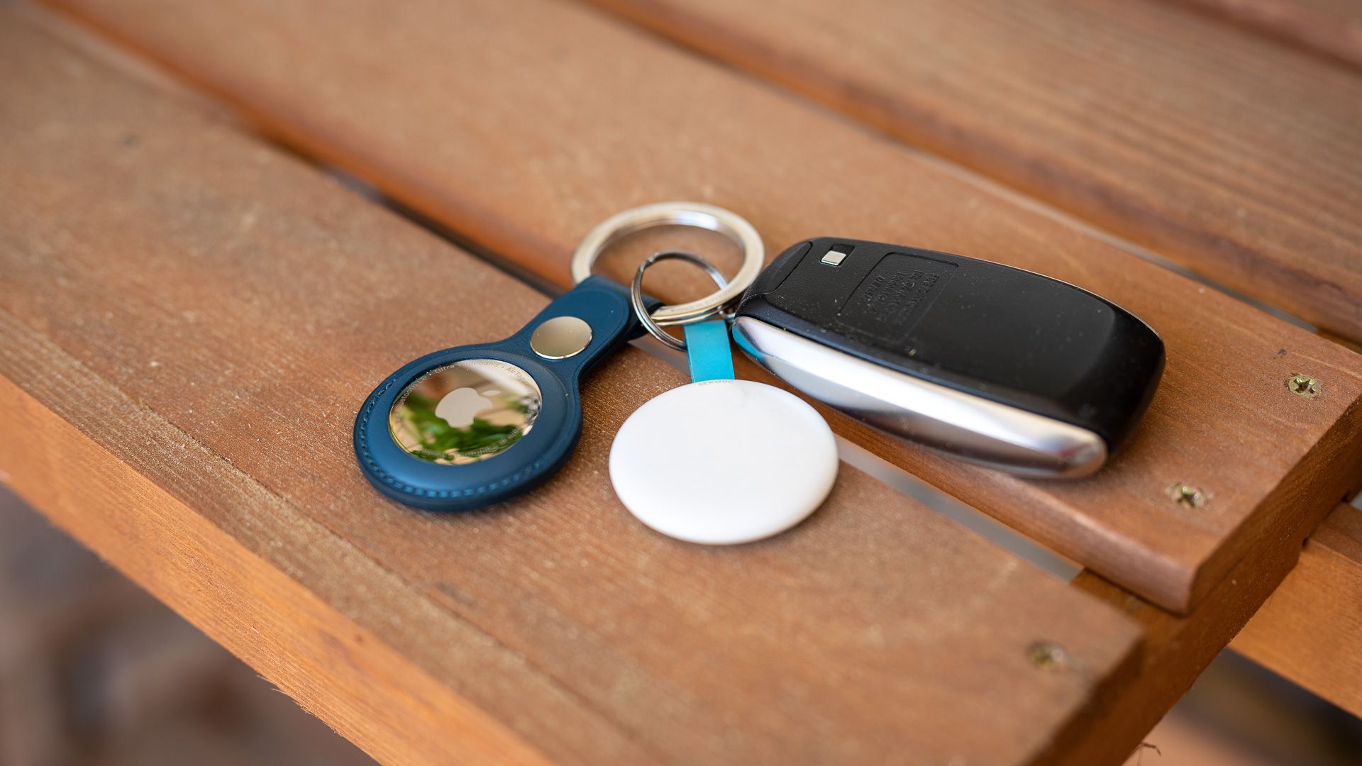 Apple AirTag in a case attached to car keys and sitting on a table